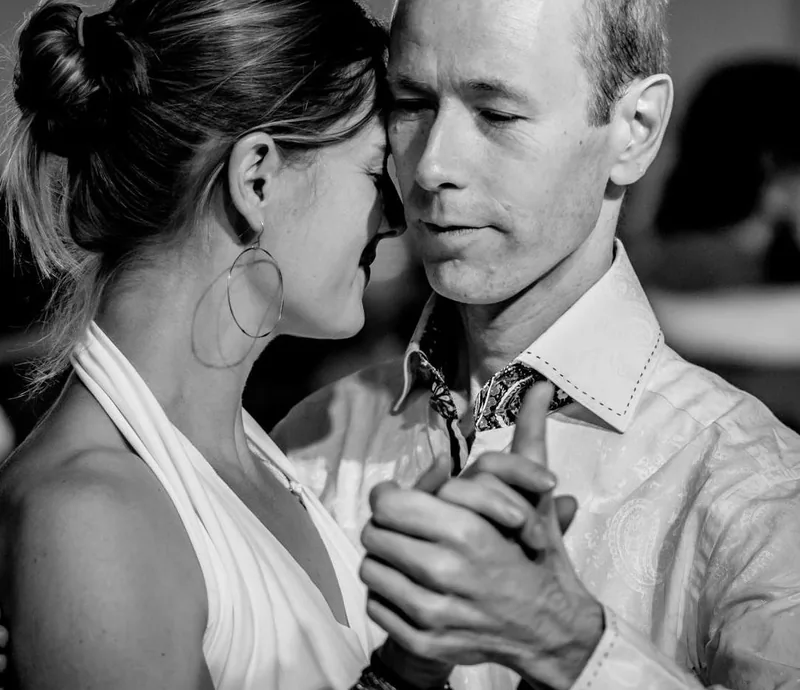 Two dancers cheek to cheek in a close hold, the connection practiced in Argentine tango dance classes in Ottawa