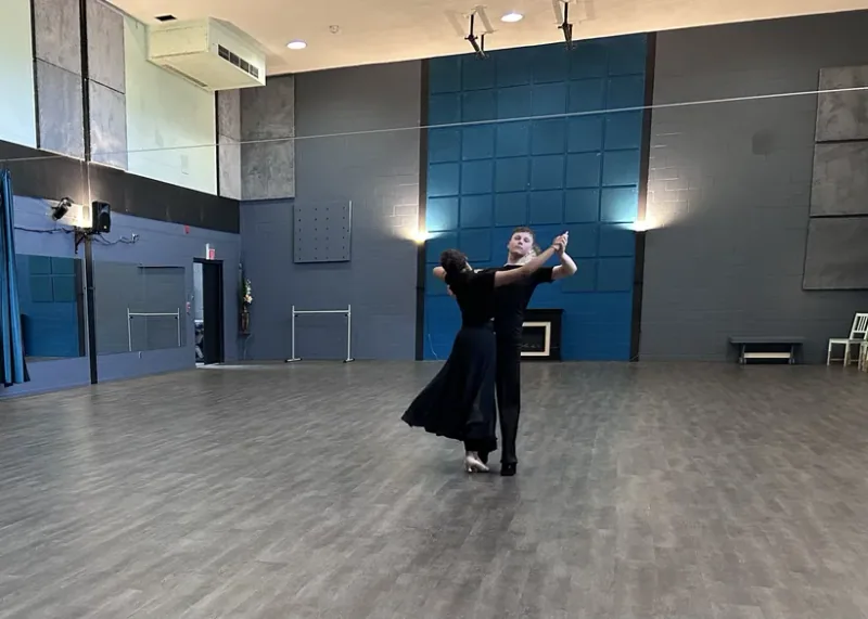 One couple dancing alone on a large studio floor in a beginner ballroom dance class at DQ Ballroom & Fitness in Ottawa