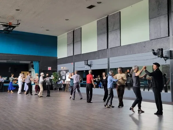 Couples spread across the floor in a beginner cha cha dance class in Ottawa at DQ Ballroom & Fitness