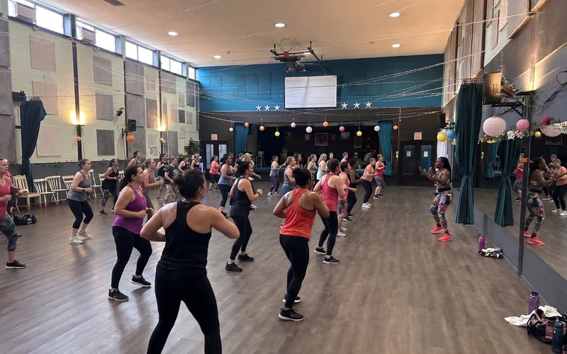 A packed Zumba class fills the Big Ballroom, the largest dance studio rental at DQ Ballroom & Fitness in Ottawa, with its stage and mirror wall in view