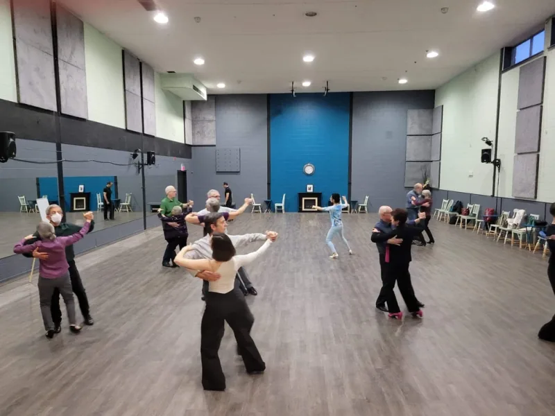 Several couples moving in line of dance during intermediate foxtrot dance classes in Ottawa at DQ Ballroom & Fitness