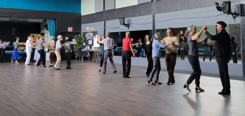 Adults practising partner steps in a beginner International Latin dance class in Ottawa at DQ Ballroom & Fitness