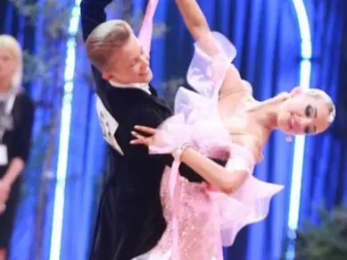 Young couple in ballroom attire dancing on a competition floor in a kids dance program in Ottawa