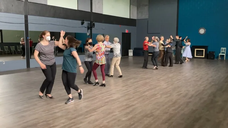 Beginner students dancing in pairs across the floor in a la salsa class in Ottawa at DQ Ballroom & Fitness