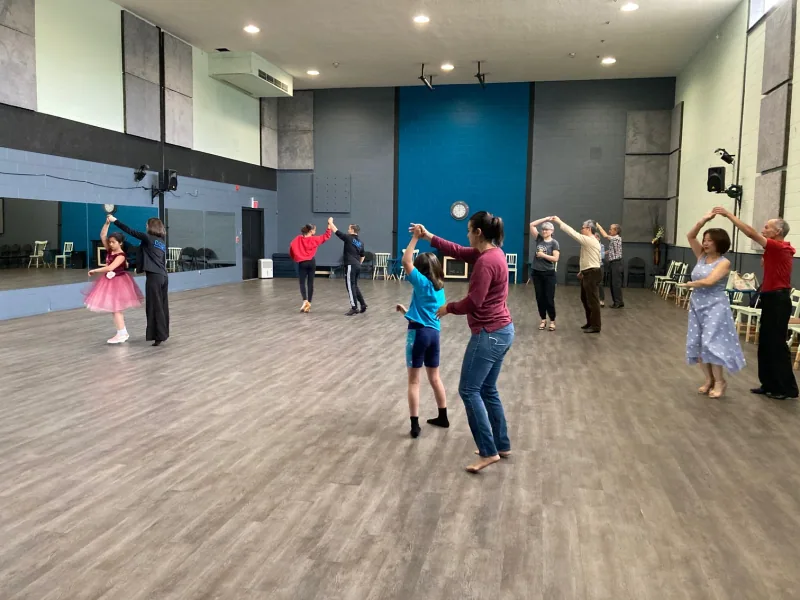 Couples turning under raised arms during a la salsa dance class in Ottawa at DQ Ballroom & Fitness