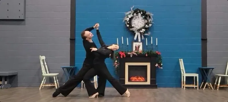 Couple in black dancewear holding a ballroom pose during an Ottawa dance class at DQ Ballroom & Fitness