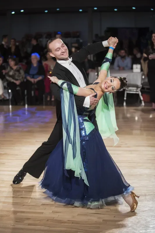 Couple in formal ballroom attire dancing during private dance lessons in Ottawa at DQ Ballroom & Fitness