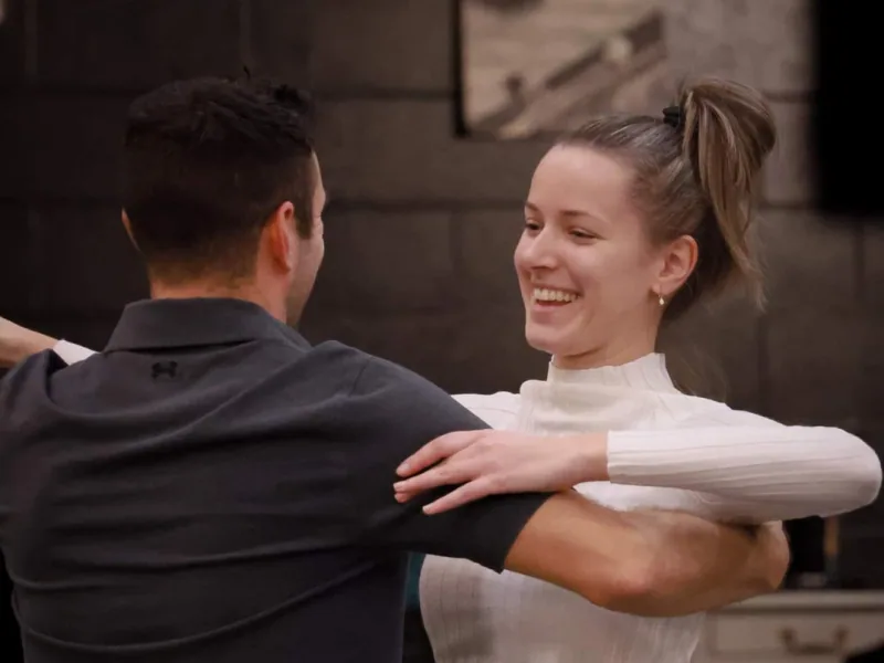 Smiling couple in a closed hold learning the basics in a beginner quickstep dance class in Ottawa