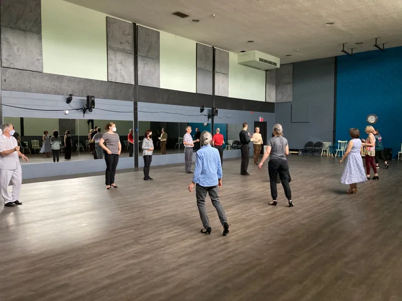 Adults spread across the studio floor in a quickstep dance class in Ottawa at DQ Ballroom & Fitness