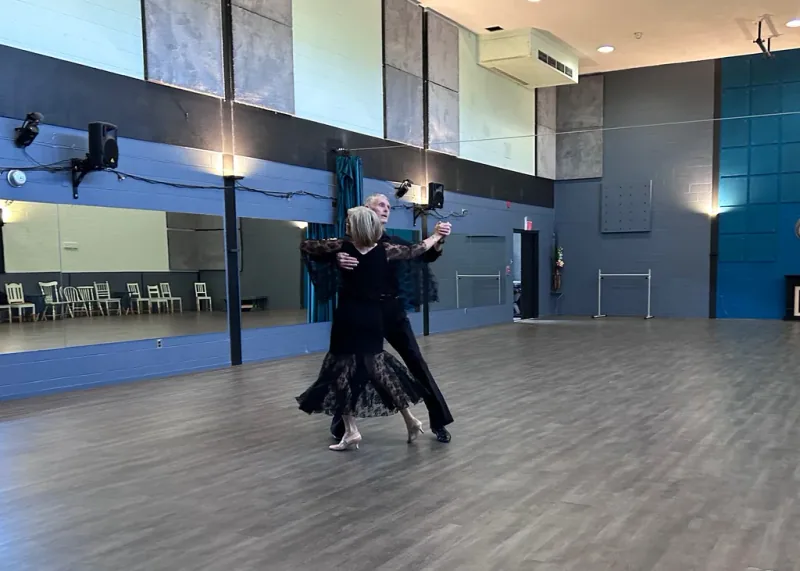 Older couple gliding across the floor in an intermediate quickstep dance class in Ottawa at DQ Ballroom & Fitness
