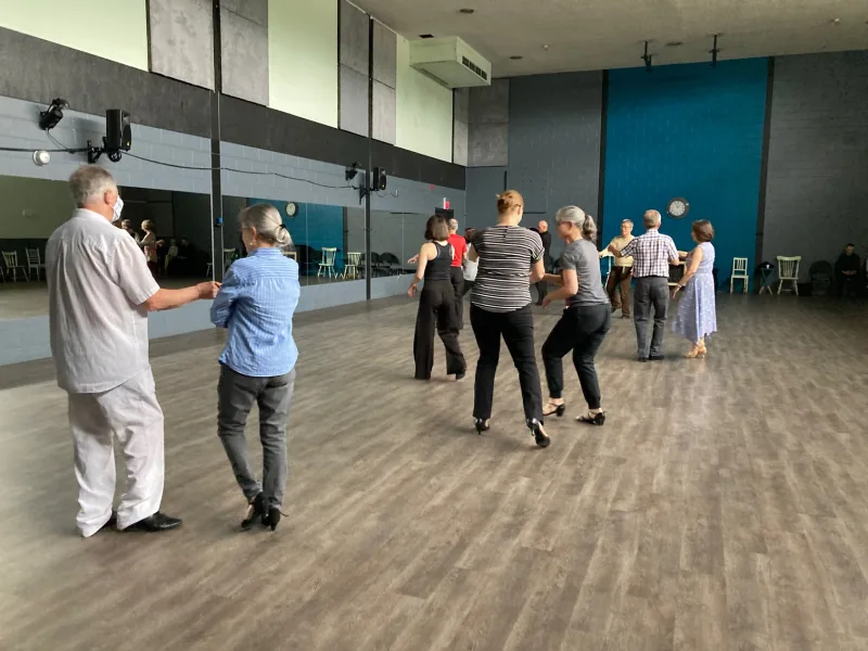 Adult students practicing footwork in an open studio during a beginner rumba dance class at DQ Ballroom & Fitness in Ottawa