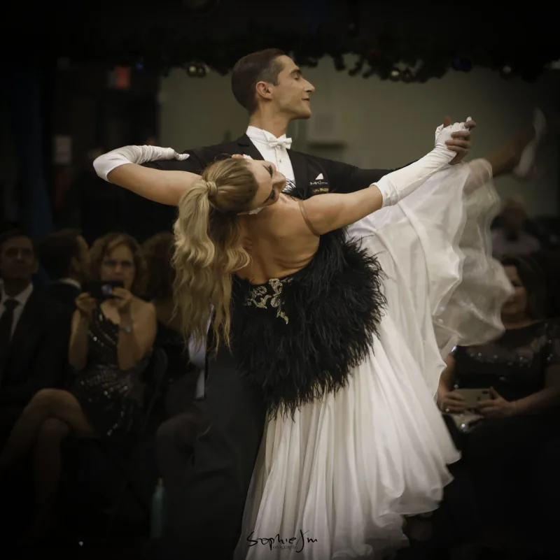 Couple in formal attire dancing the waltz at a showcase, the kind taught in waltz dance classes in Ottawa