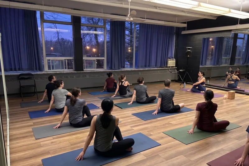 Group seated on mats at dusk in a wood-floor room available through yoga studio rentals at DQ Ballroom & Fitness in Ottawa